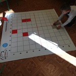 Dzieci układają na macie do kodowania kolorowe kartoniki..jpg