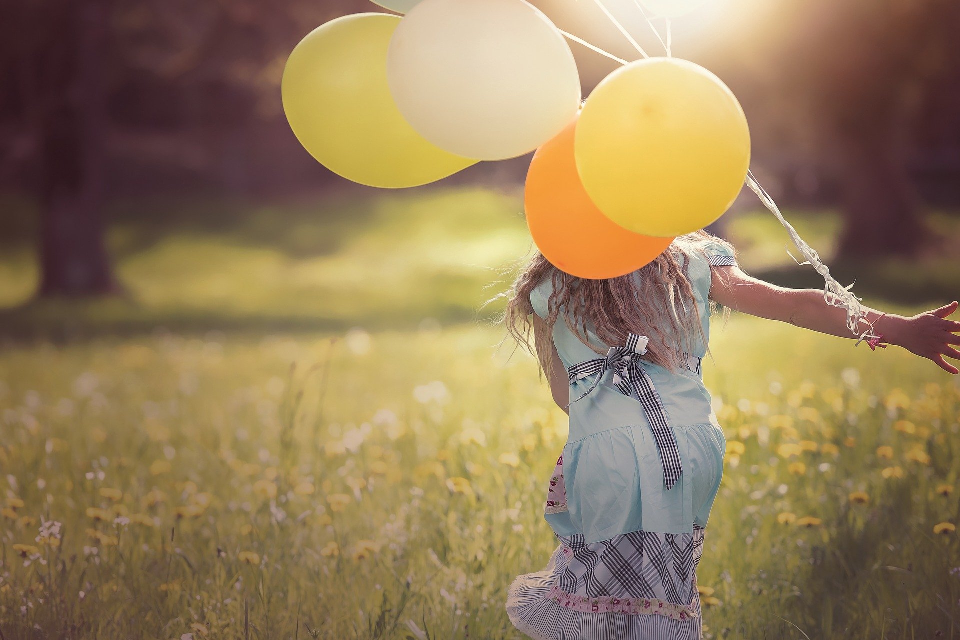 dziewczynka z żółtymi balonami na łące.jpg