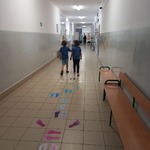 Uczennica i Uczeń  z dzwonią dzwonkiem na Alarm Czytelniczy na korytarzu szkolnym.jpg