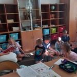 grupa uczniów słucha czytanej książki przez nauczyciela (13).jpg
