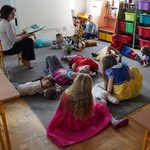Grupa uczniów słuchających i nauczyciel czytający książkę.jpg (6).JPG