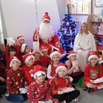 Dzieci ze Św. Mikołajem siedzą wokół klasowej choinki.jpg